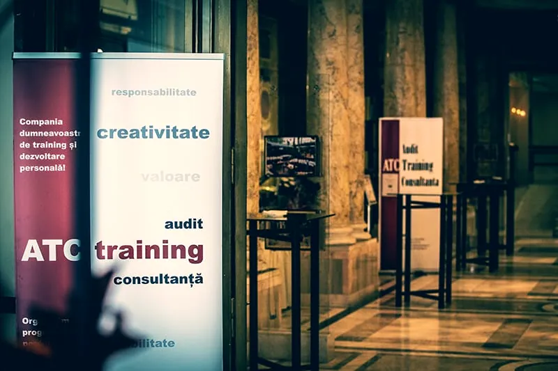 Roll-up-uri ATC Training cu cuvintele audit, training, consultanță, în holul cu coloane al unui hotel